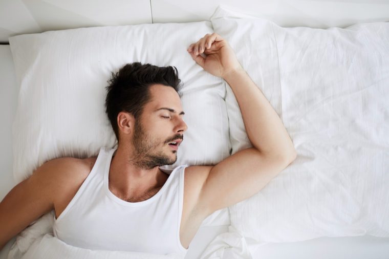 Top view of young attractive man sleeping with mouth open