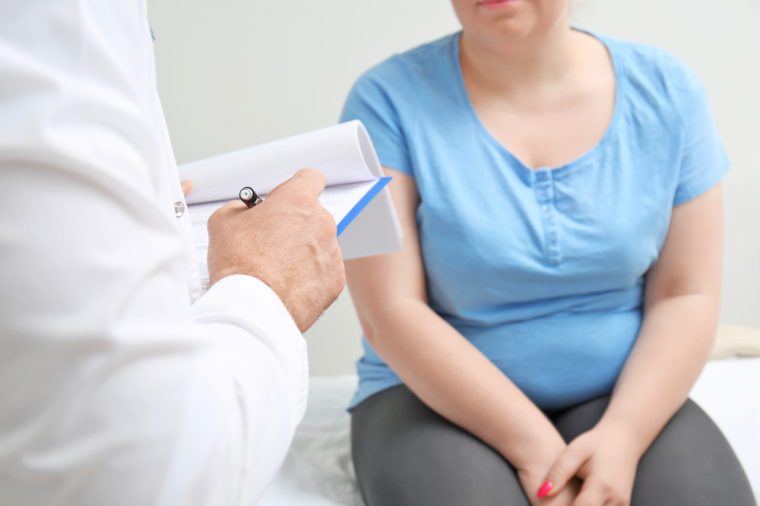 Overweight woman discussing test results with doctor in hospital