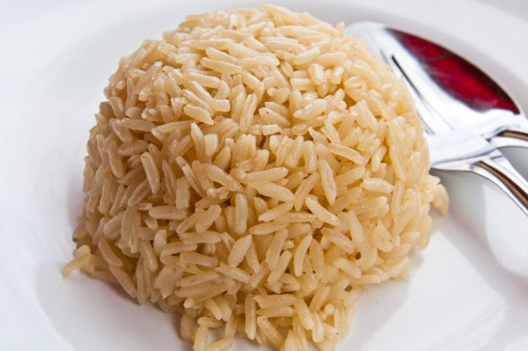 White rice on a plate, spoon on the side