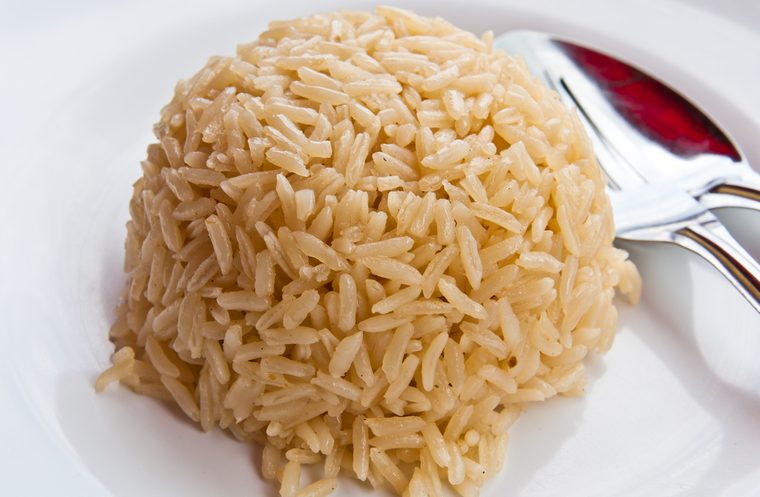 White rice on a plate, spoon on the side