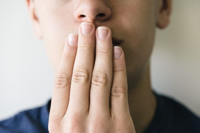 Boy covering the mouth with his hand