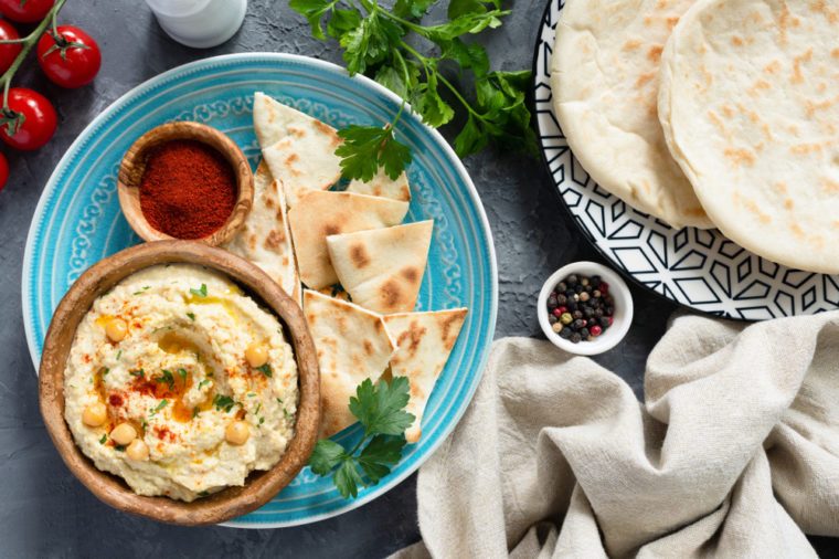 Arabic Chickpea Hummus and Pita Bread. Traditional middle eastern or arabic food. Meze party plate. Pita, hummus, paprika and parsley.