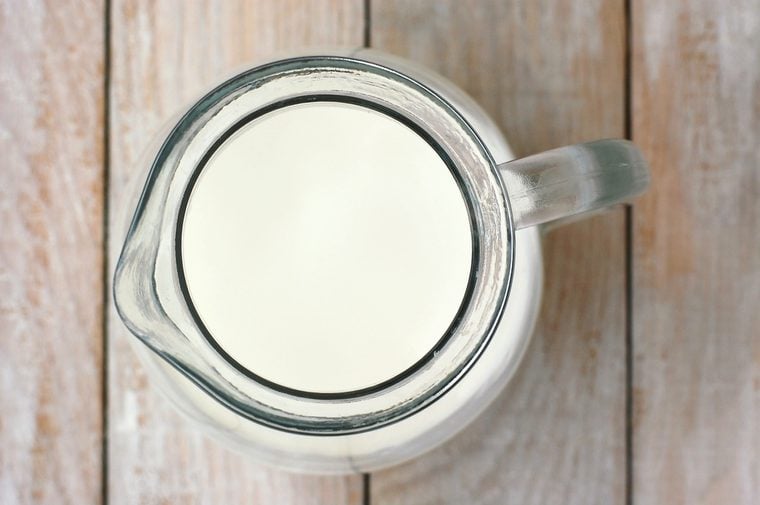 White milk in the jug on the wooden background, overhead horizontal view.Dairy product.Milk from cow.