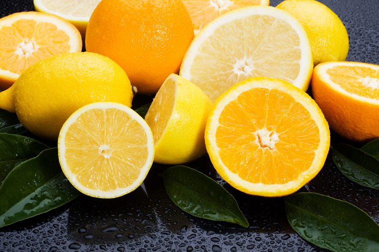 Lemon, orange and grapefruit on wet background