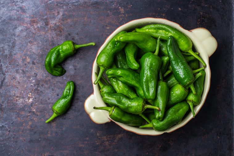 Food and drink, still life concept. Raw green peppers pimientos de padron mexican jalapeno traditional spanish tapas on a table. Selective focus, top view flat lay overhead