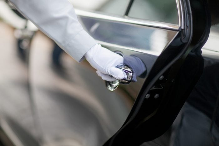 Closeup of Chauffeur opening car door with glove