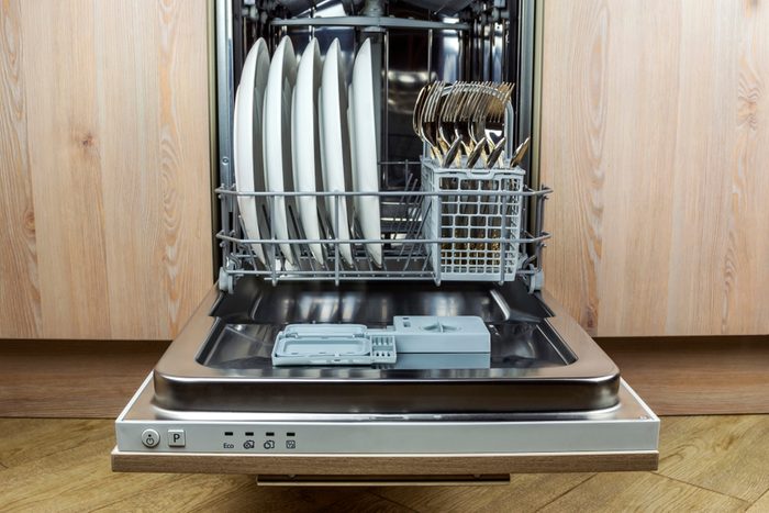 Dishwasher with clean cutlery and plates