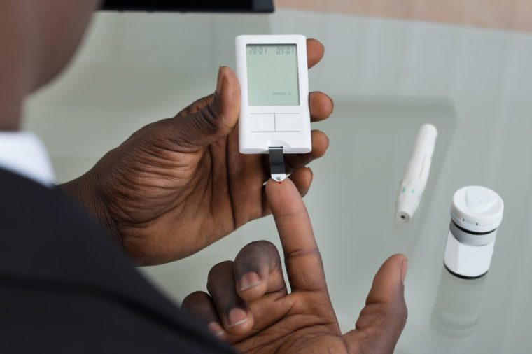 Close-up Of Patient Hands Measuring Glucose Level Blood Test With Glucometer