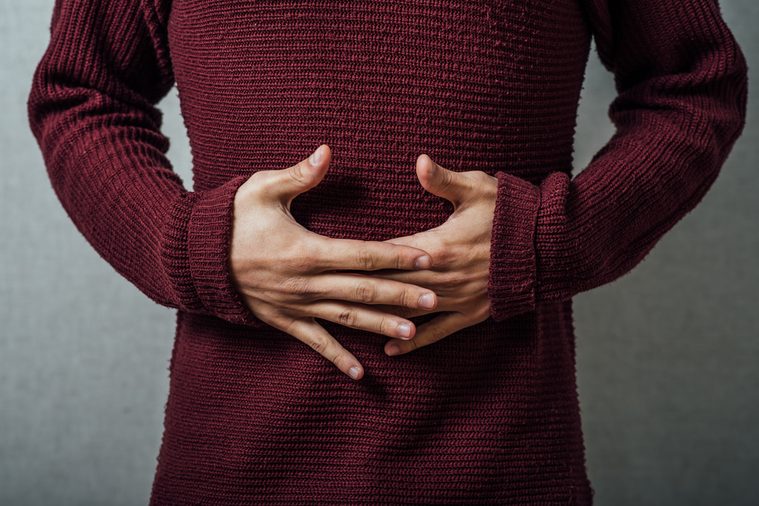 person holding their stomach in pain or indigestion