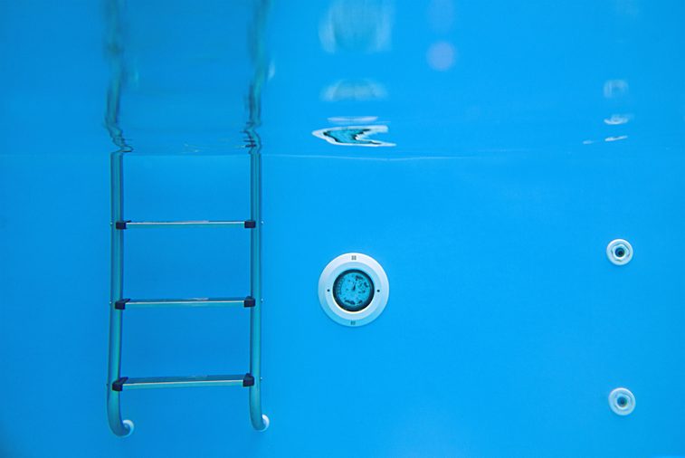 Background of view of the swimming pool with metal ladder underwater