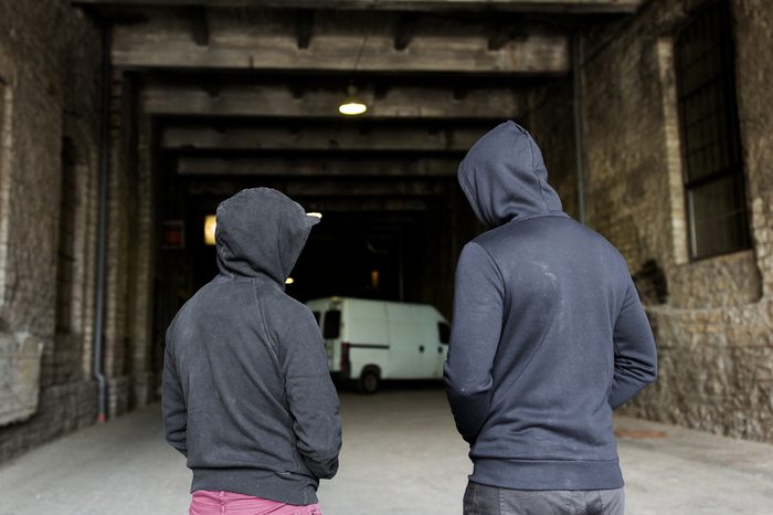 criminal activity, addiction, people and social problem concept - close up of addict men or criminals in hoodies on street