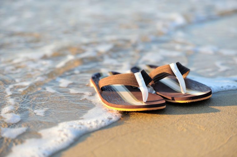 Summer vacation concept. Flip flops on a sandy ocean beach