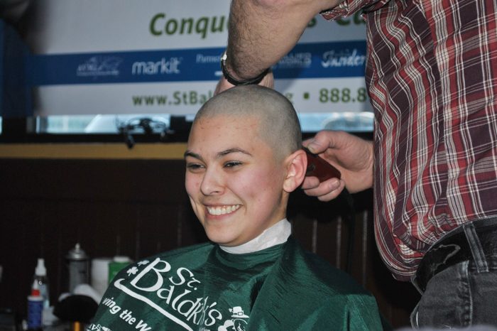 Alaska state House page Hanna Davis smiles as she gets her head shaved at a fund-raiser for St. Baldrick's Foundation, in Juneau, Alaska. Davis was among a number of state legislators, pages and community members who got their heads shaved for the childhood cancer research charity