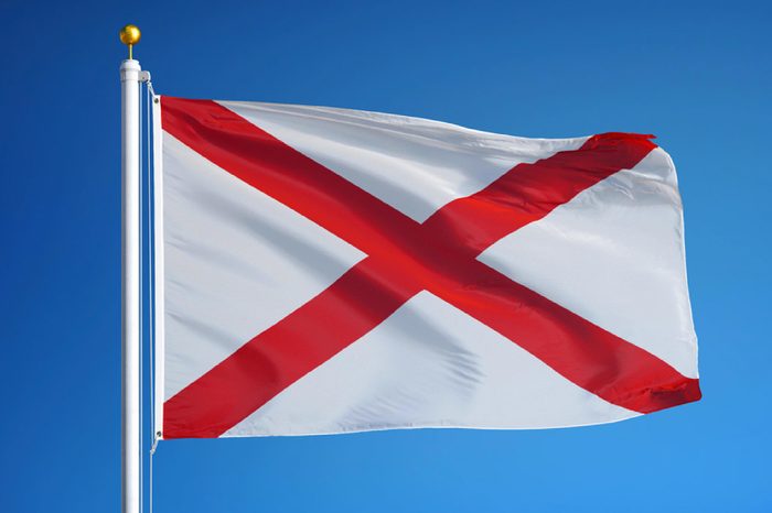 Alabama (U.S. state) flag waving against clear blue sky, close up, isolated with clipping path mask alpha channel transparency, perfect for film, news, composition