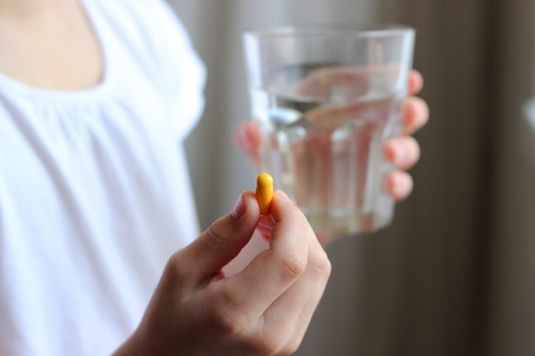 a pill and a glass of water in children's hands. pills in children's hands. children's diseases. concept of health.