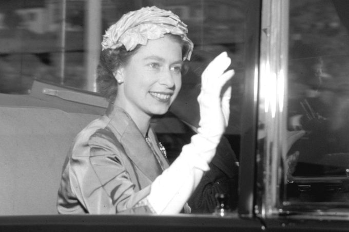 Britain's Queen Elizabeth II waves to the crowd whilst travelling to a theatre in London