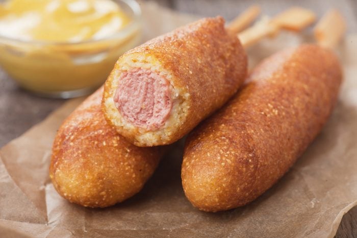 Home made corn dog fried sausage skewer with mustard