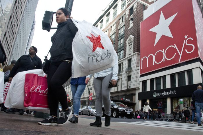 Shoppers carry bags as they cross a pedestrian walkway near Macy's in Herald Square in New York.