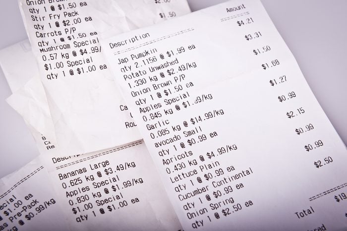 Pile of generic grocery receipts with costs shown in shallow focus