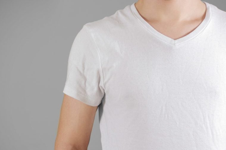 White t shirt on a young man template on gray. Isolated on grey background.