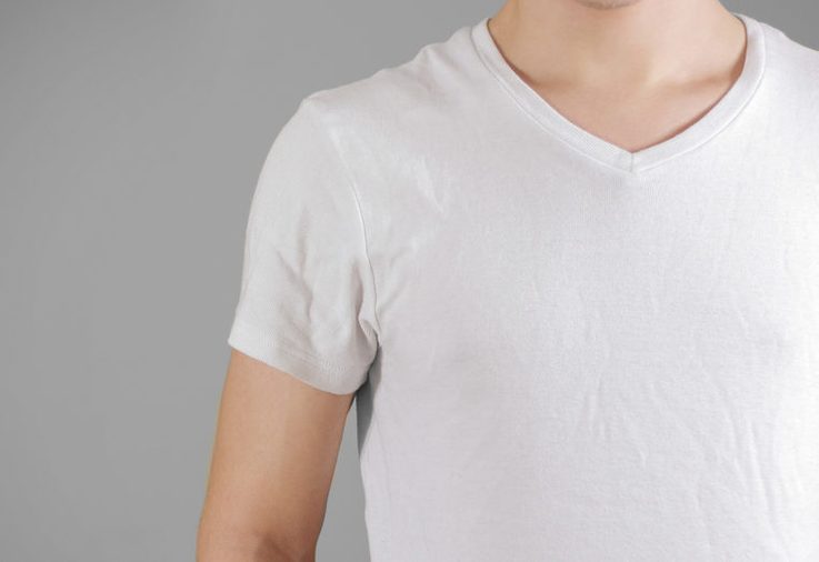 White t shirt on a young man template on gray. Isolated on grey background.