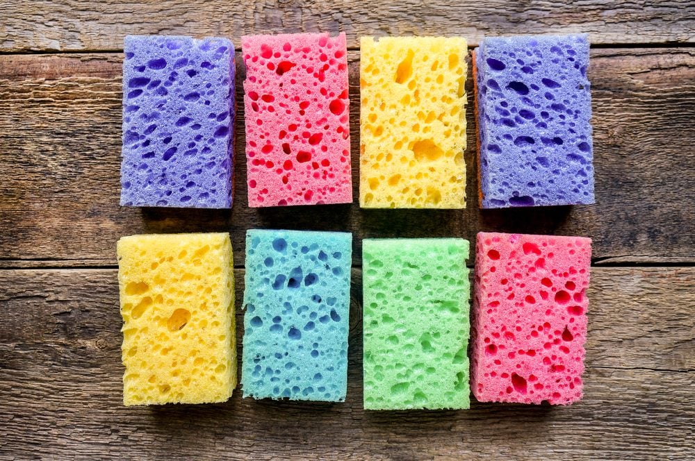 Kitchen cleaning set of multicolored sponges on wood background