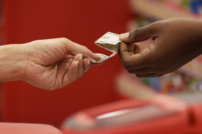 Shopping; Cash A customer hands cash to a Target employee at a register at a Target store in Colma, Calif., . A woman walks through the toy department at a Target store in Colma, Calif., Friday, Nov. 23, 2012. Black Friday, the day when retailers traditionally turn a profit for the year, got a jump start this year as many stores opened just as families were finishing up Thanksgiving dinner. Stores are experimenting with ways to compete with online rivals like Amazon.com that can offer holiday shopping deals at any time and on any day. (AP Photo/Jeff Chiu
