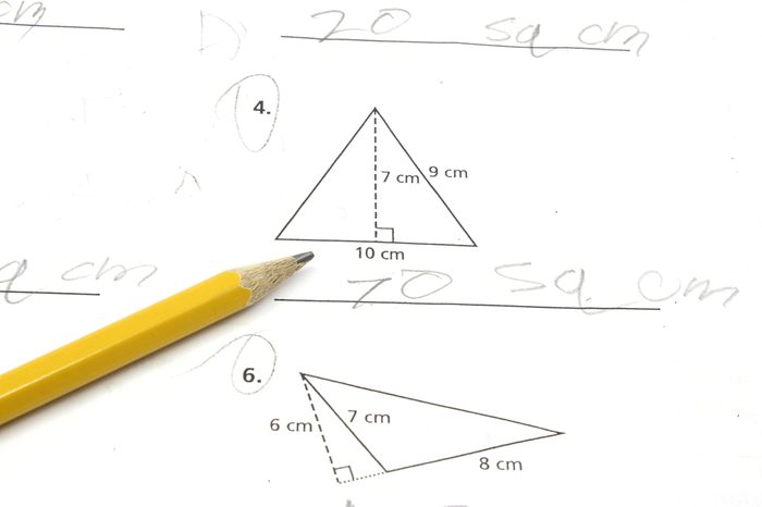 Paper and pencil on a math problem figuring out the area of a triangle.