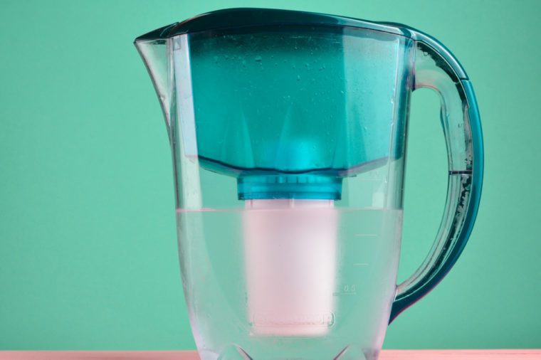 Plastic jug water filter on a blue pastel background.