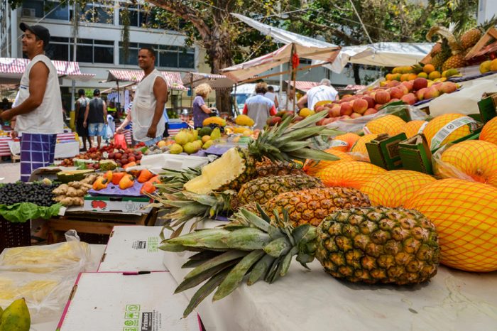 Rio de Janeiro, Brazil - Dec 15, 2017: Assortment of fresh tropical fruits at a street market in Rio de Janeiro, Brazil - focus on pineapples
