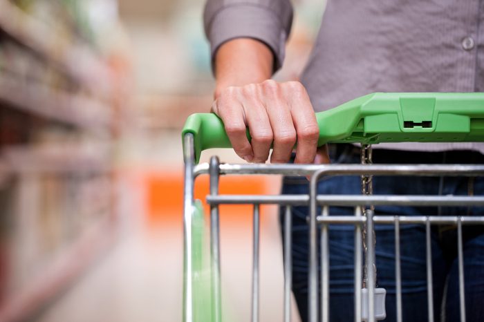 Closeup of female shopper with trolley at supermarket