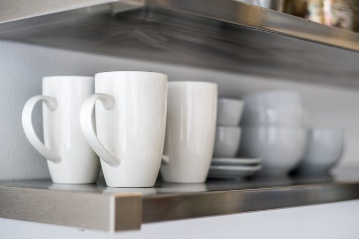 Ceramic bowls and mugs on kitchen shelf