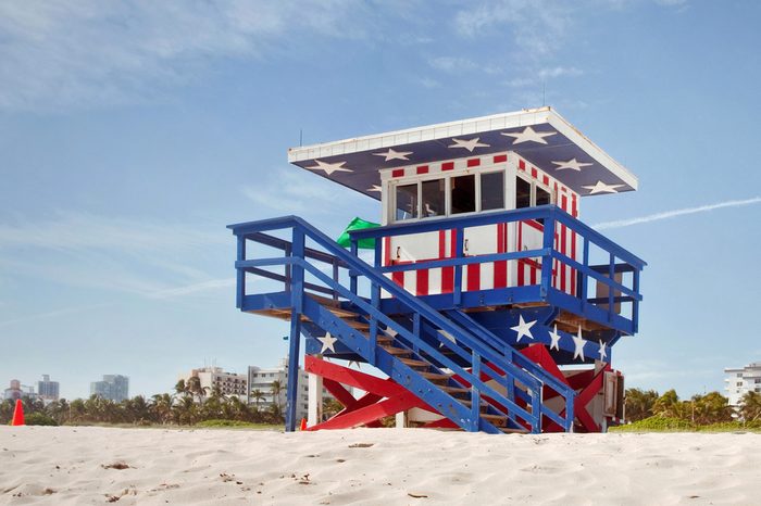 Miami Beach Florida, lifeguard house in a typical colorful Art Deco style,painted in the American flag colors on a summer day, with blue sky and Ocean in the background. Famous travel location.