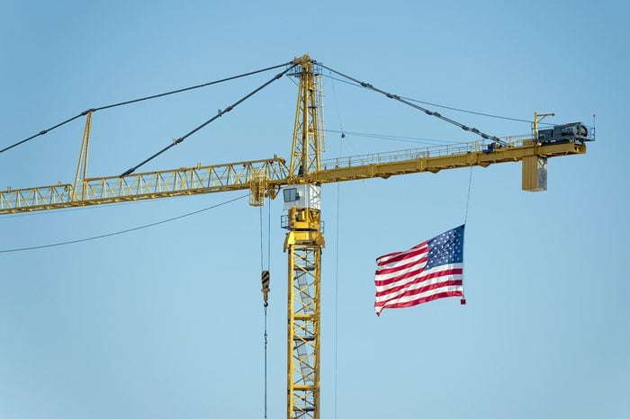 yellow industrial big crane with american flag