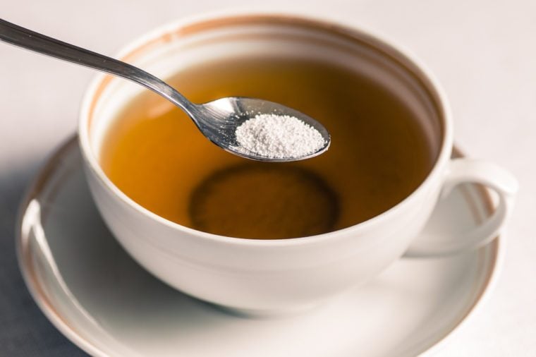 Cup of tea with sweetener sorbitol in a spoon