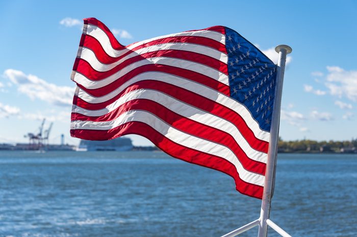 United States of America flag flying or waving in boat or cruise in the Hudson River. Beautiful symbol of freedom in New York city.