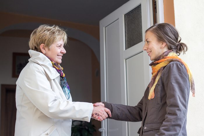 Senior women greeting young girl in the doorway