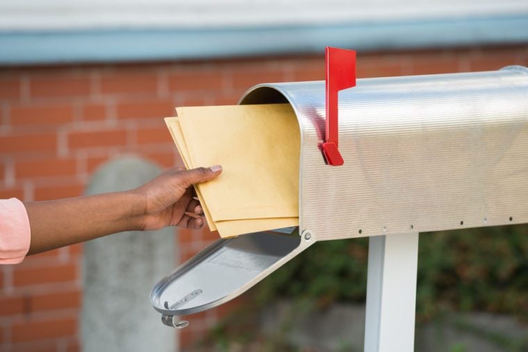 Close-up Of Person's Hand Putting Letters In Mailbox