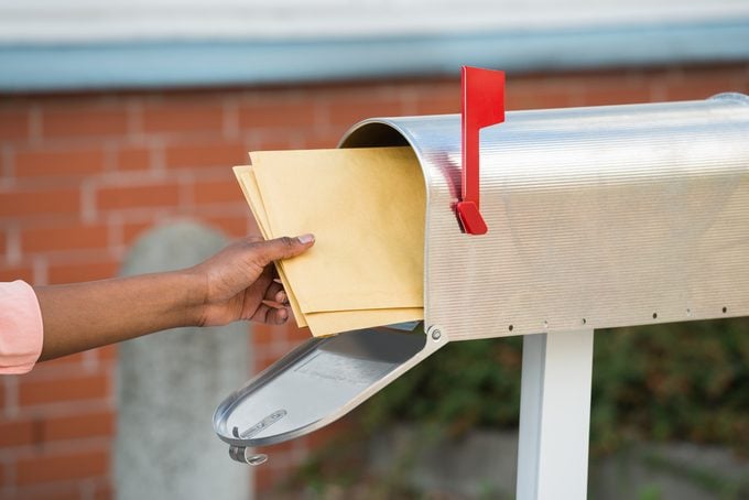 Close-up Of Person's Hand Putting Letters In Mailbox