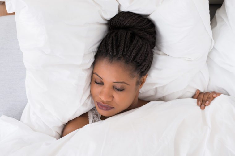 High Angle View Of African Woman Sleeping On Bed