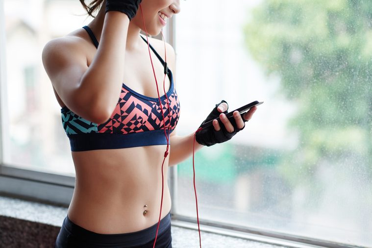 Young woman choosing music for sports training