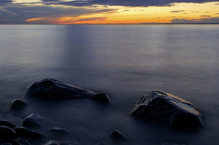 Waves Lap Around Rocks of Lake Superior's Wisconsin Shoreline During a Vibrant Sunset