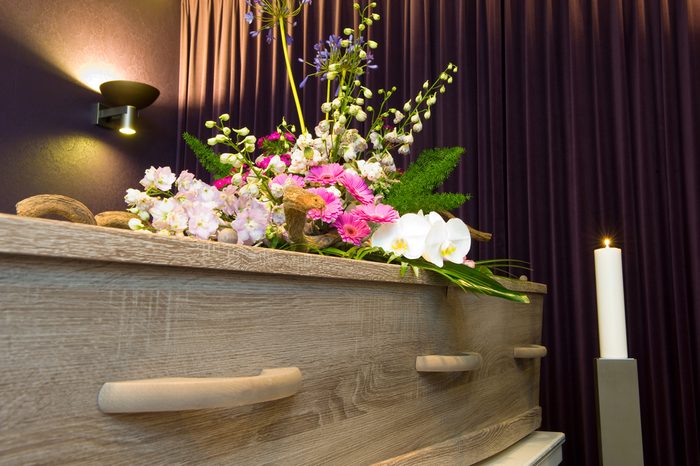 A coffin with flower arrangement in a morgue