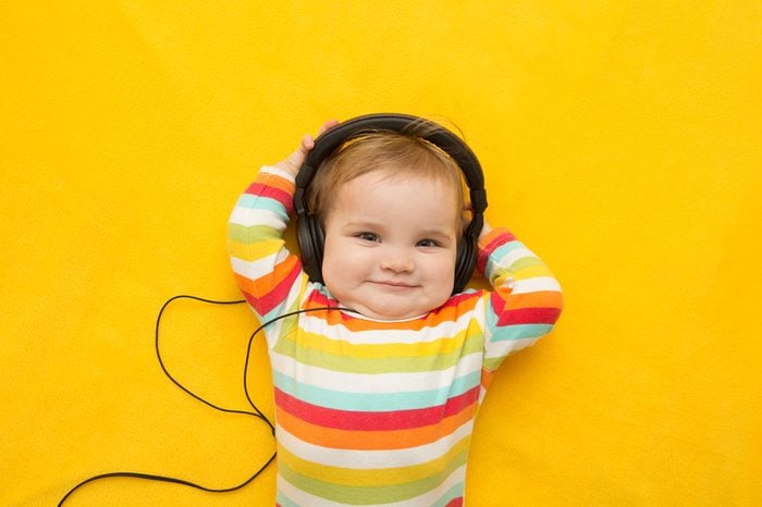 the baby with headphones on a yellow background