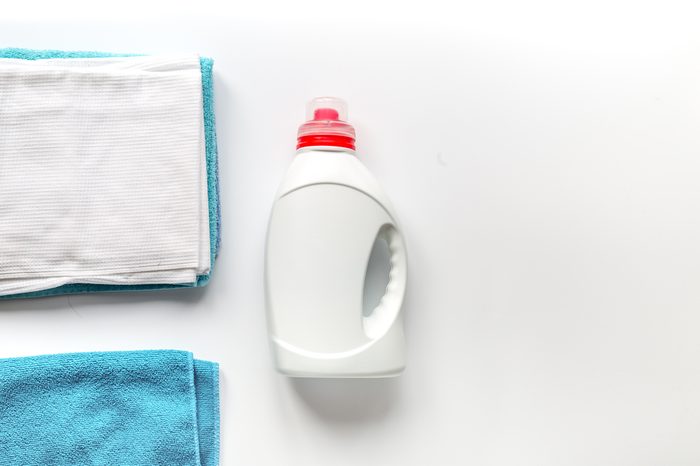 housekeeping set with towels and plastic bottles in laundry top view mockup