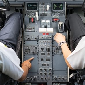 view of business jets cockpit. Two pilots operate a switches of aircraft system prior to departure.