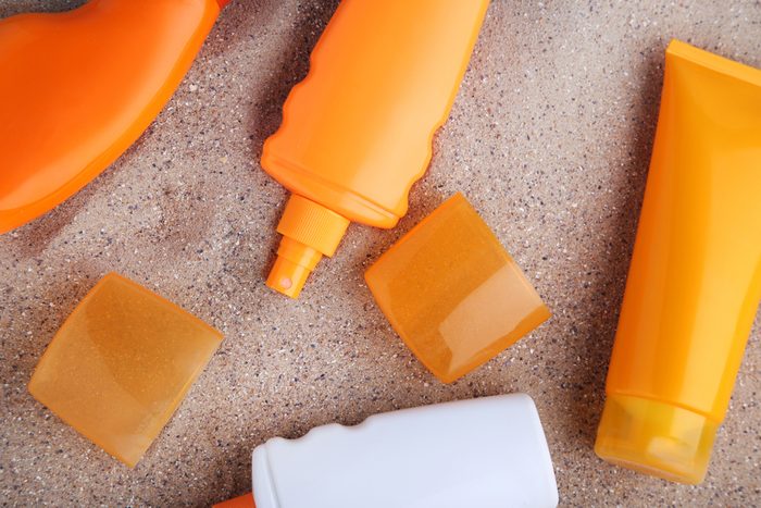 Sunscreen bottles on beach sand