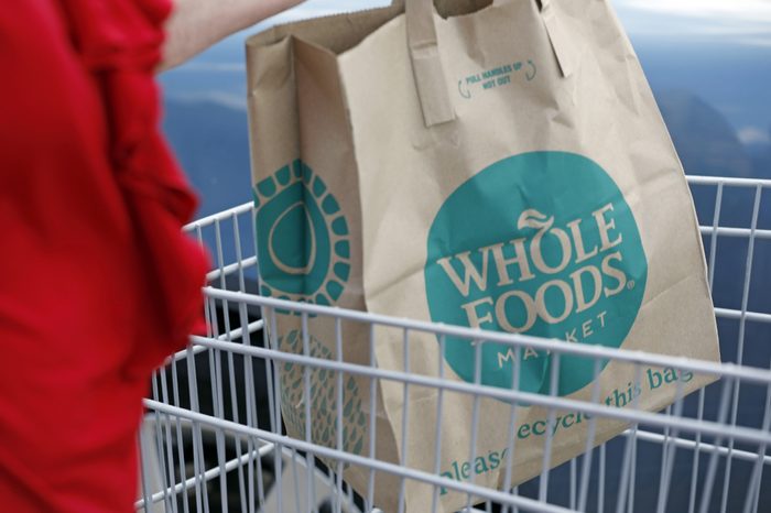 A Whole Foods Market customer carries her purchase from the Jackson, Miss., store . Amazon is buying Whole Foods Market in a deal valued at $13.7 billion, uniting the on-line giant with the grocery store chain that touts fresh organic foods