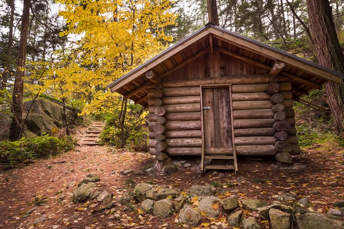 Log cabin in a forest in the fall.