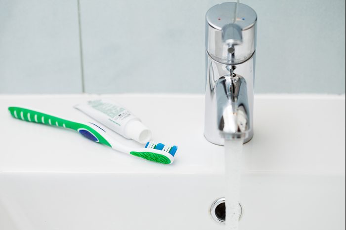 Tap and toothbrush over the clean white sink